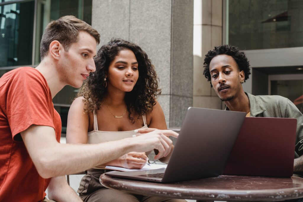 Group of multiethnic coworkers discussing startup project on laptops together